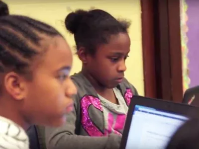 Two students working on laptops
