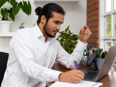A man sitting at a desk working on a laptop

