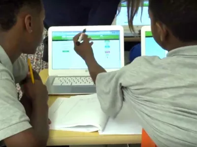 Photo of students working together on laptop computers
