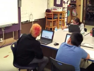 Photo of seated students looking at projector in front of classroom

