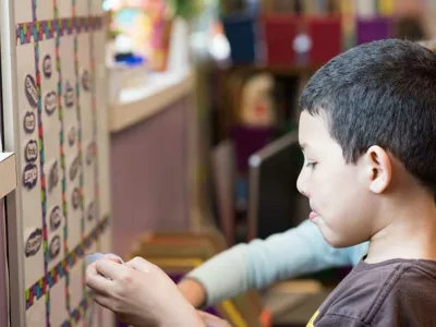 Male student looks over colorful board on wall
