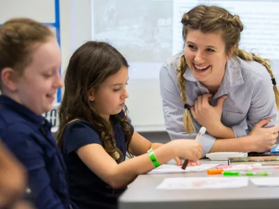 Teacher smiles as she talks with a student
