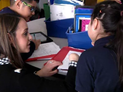 Photo of teacher working with two students
