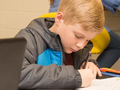Student sits at desk, working

