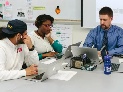 Teacher works with two students
